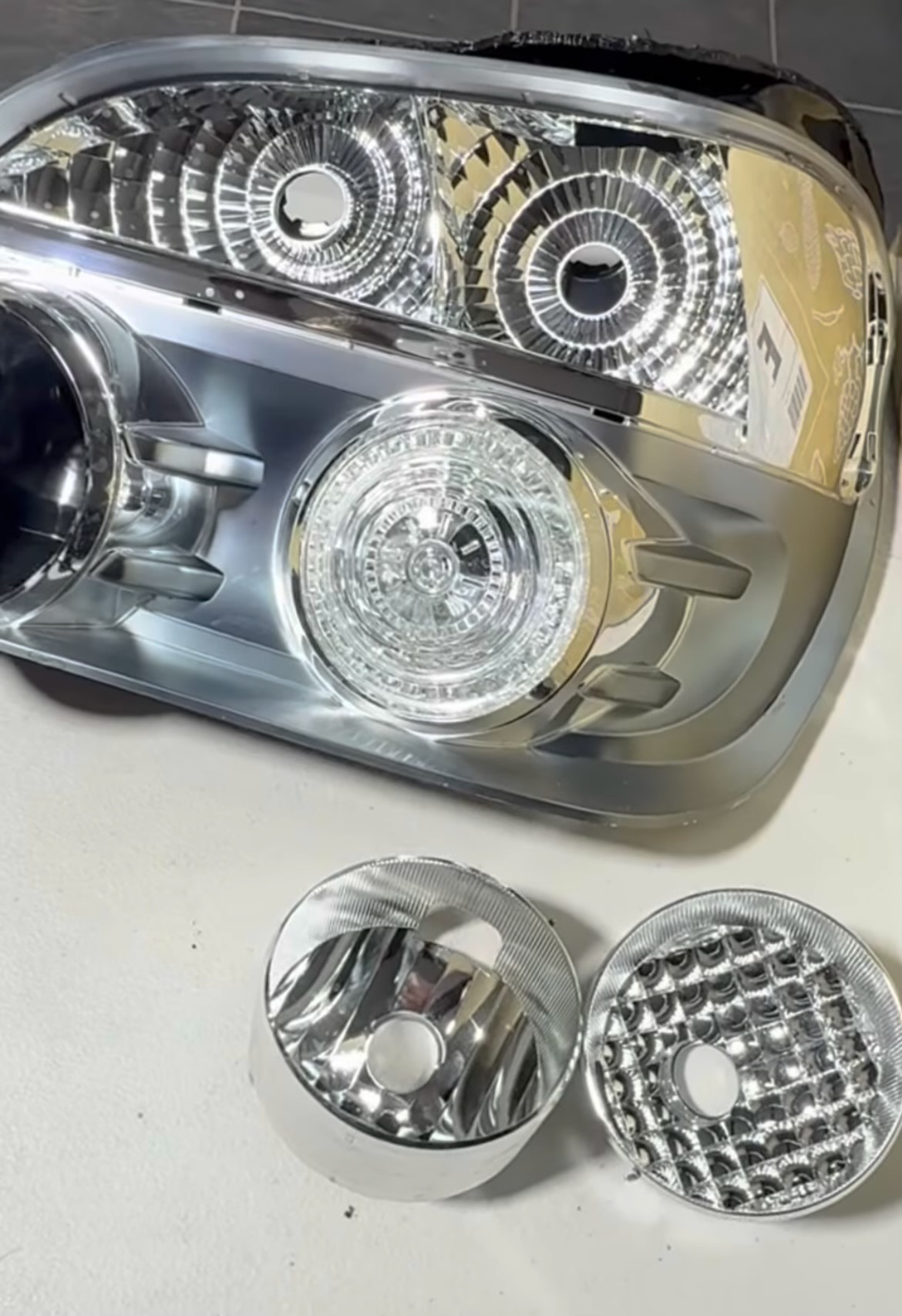 Chrome reflector inserts laid out beside an assembly ready for resealing